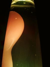 Close-up of lit candle against black background