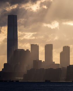 Buildings in city against sky during sunset