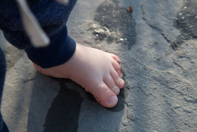 Low section of child standing on rock