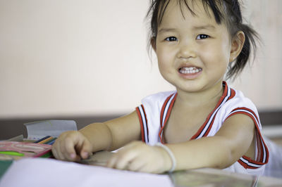 Portrait of smiling girl sitting at table