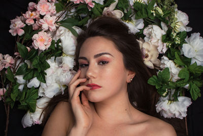 Portrait of woman with pink flowers in sunlight