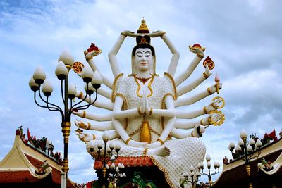 Low angle view of statue against temple building against sky