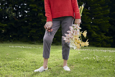 Woman in red sweater with fresh cut flowers