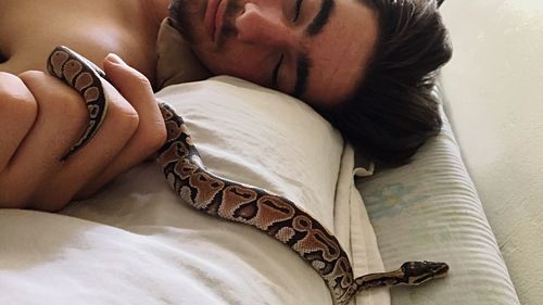 Close-up of woman sleeping on bed at home