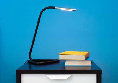 Close-up of electric lamp against blue wall