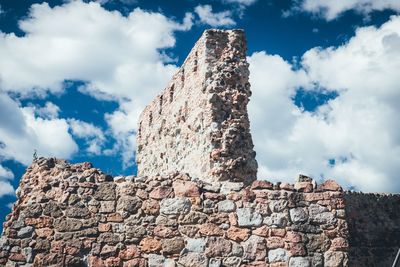 Low angle view of old stone wall against sky