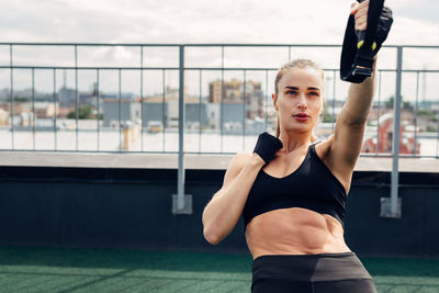 Woman exercising while standing on terrace