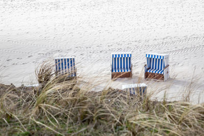 Hooded beach chairs on sand at beach