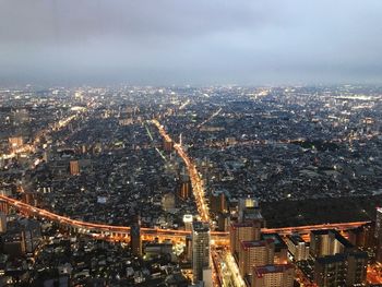 High angle view of illuminated city street against sky at night