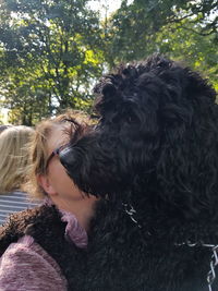 Close-up of woman with dog against trees