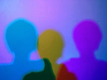 Close-up of silhouette people against blue background