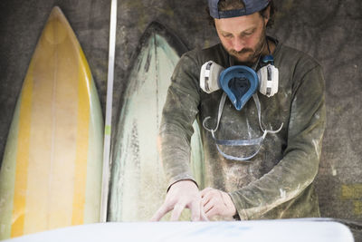 Surfboard shaper measuring a new design