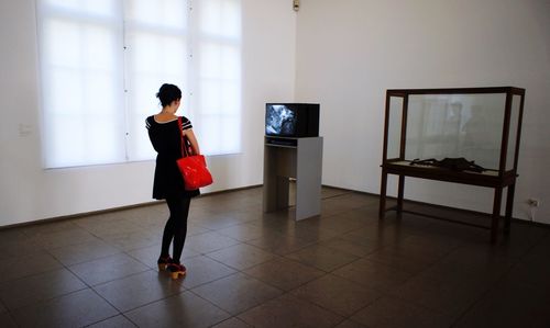 Full length of woman standing on mobile phone