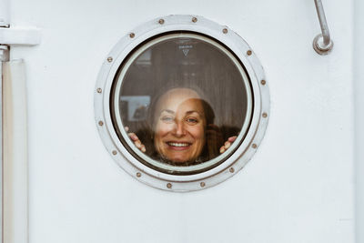 Portrait of woman looking door window