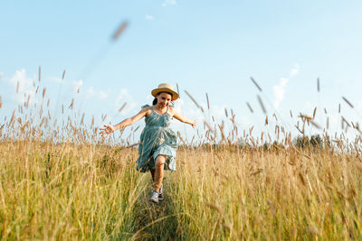 Full length of child standing on field against sky