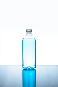 Close-up of glass bottle against blue background