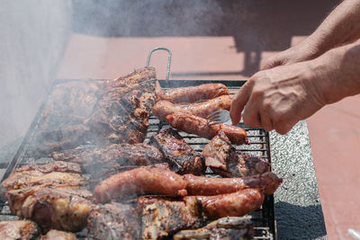 Close-up of hand holding barbecue grill