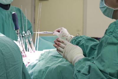 Midsection of surgeons operating patient at hospital