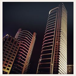 Low angle view of illuminated skyscraper against sky at night