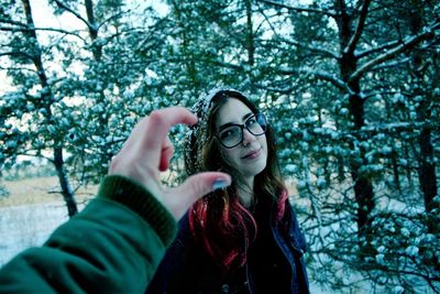 Cropped image of hand against woman during winter