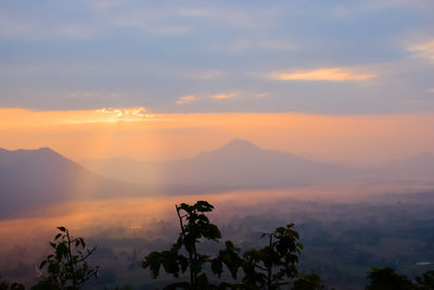 Scenic view of silhouette mountains against orange sky