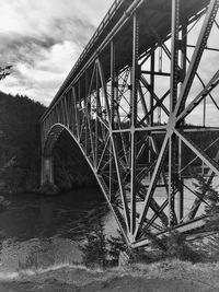 Low angle view of bridge over river against sky