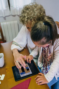 Rear view of people working on table