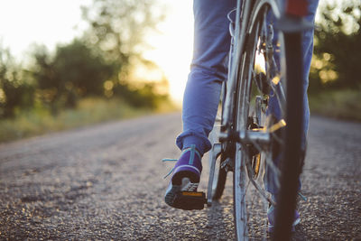 Low section of man riding bicycle on road