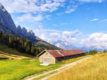 Mountain stable on field against sky and mountains