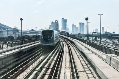 Railroad tracks in city against sky