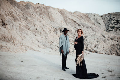 Full length of friends standing on land against sky