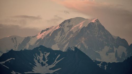 Scenic view of snowcapped mountains against sky during sunset