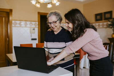 Granddaughter teaching her grandmother something on the laptop