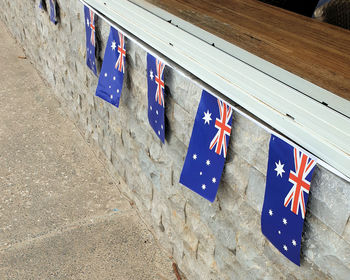 Low angle view of flags against blue wall