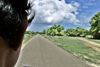 Road passing through landscape against cloudy sky