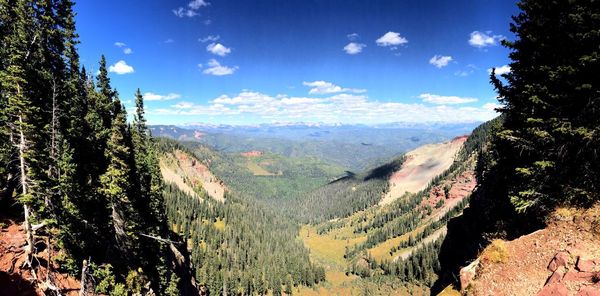 Panoramic shot of calm river along rocky mountains