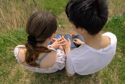 High angle view of women and man sitting on grass