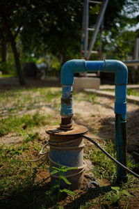 Close-up of faucet against blue sky in park