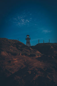 Lighthouse by sea against sky