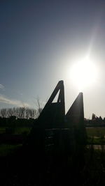 Silhouette built structure on field against sky