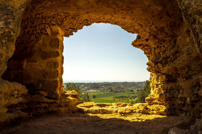 Scenic view of rock formation seen through cave