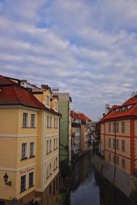 Canal amidst buildings in town against sky
