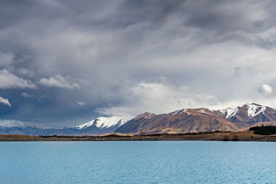 A scenic landscape of new zealand southern alps and lake pukaki with blue sky and clouds.