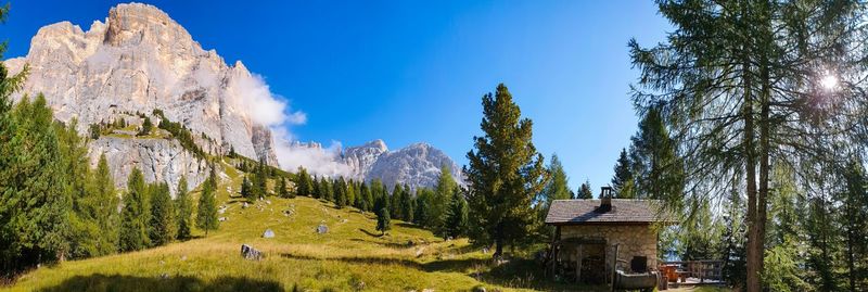 Panoramic shot of trees and hut on mountain against sky