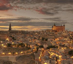 Aerial view of cityscape against cloudy sky