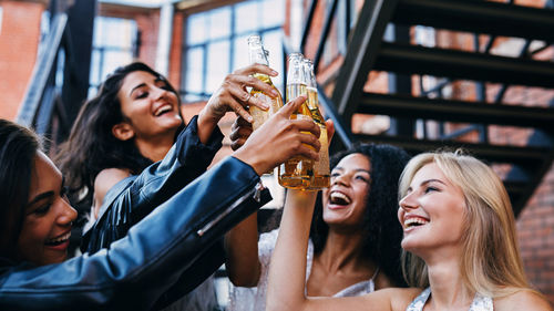 Happy friends toasting drinks at party