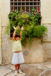 Full length of woman standing against wall