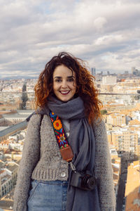 Portrait of smiling woman standing against cityscape