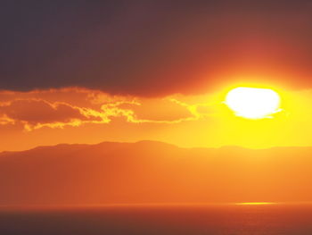 Scenic view of sea against romantic sky at sunset