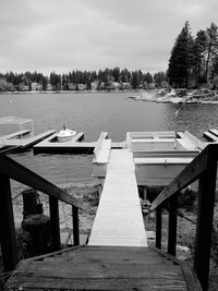 High angle view of steps leading towards lake against cloudy sky